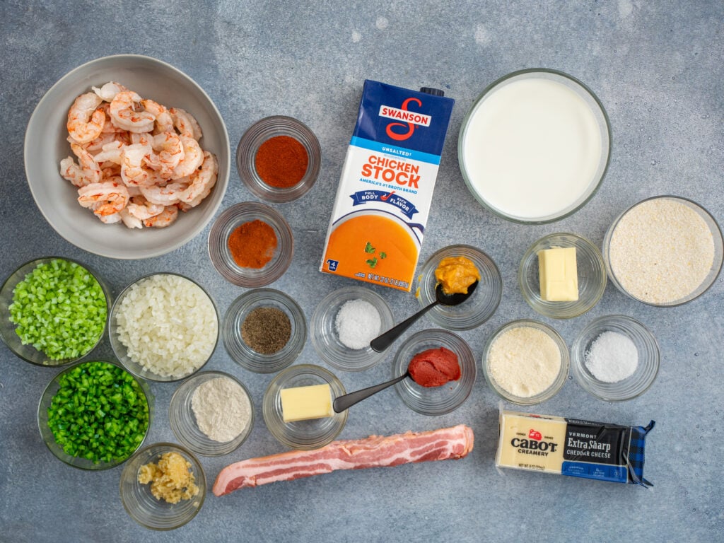 ingredients to make shrimp and grits displayed on grey background