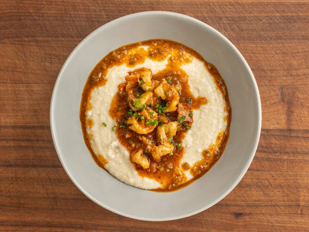 grey bowl filled with grits topped with shrimp gravy