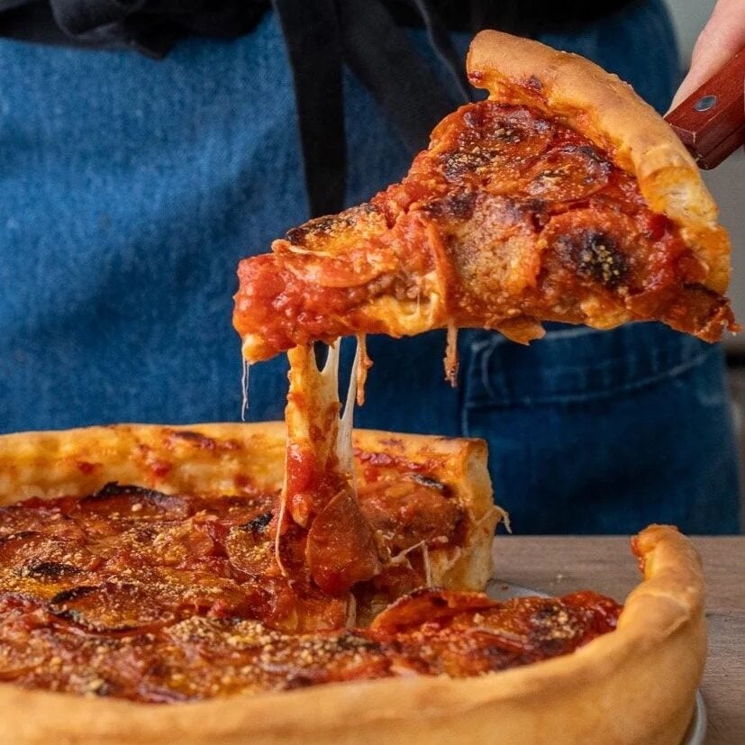 pulling up a slice of deep dish pizza