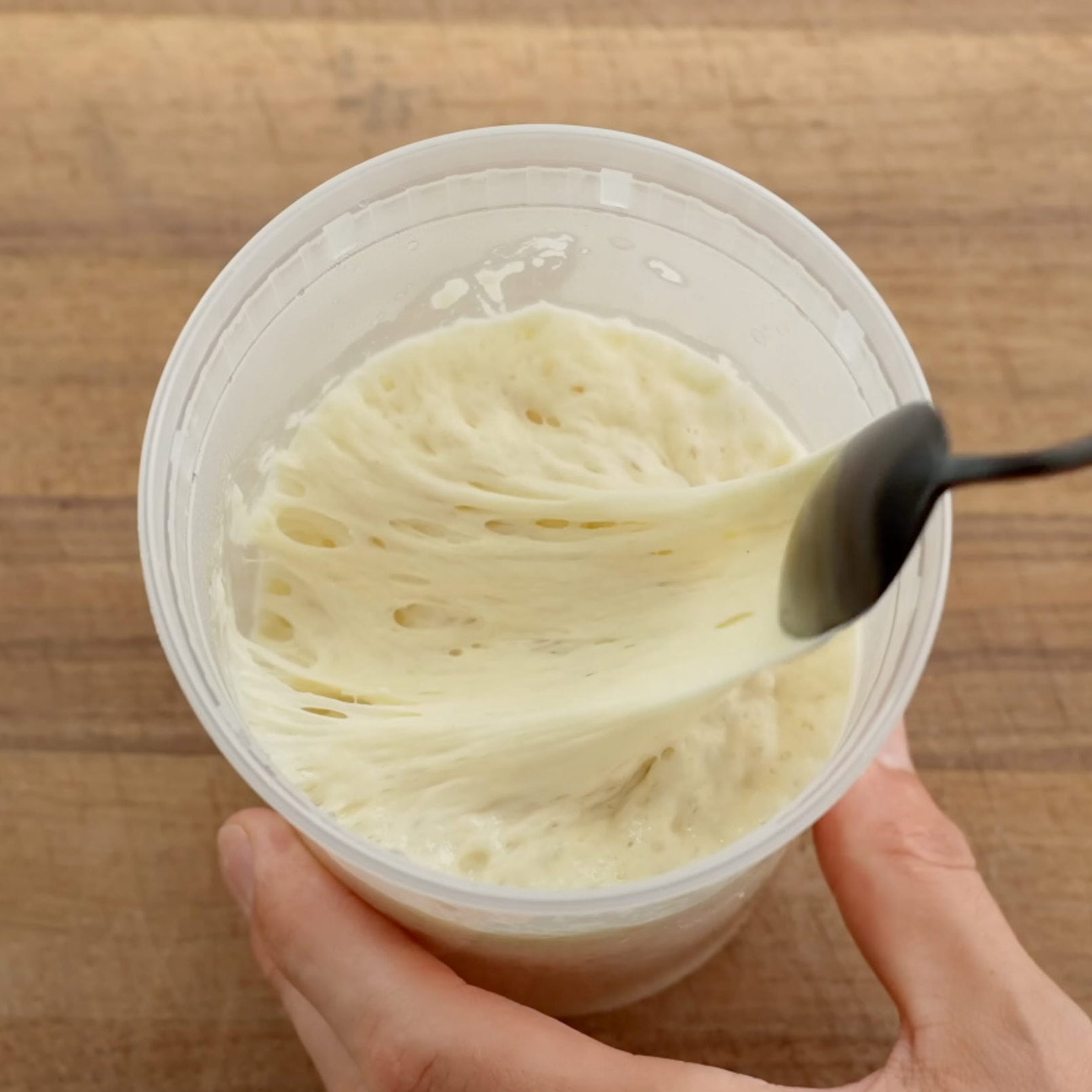 black spoon pulling through ripe leaven