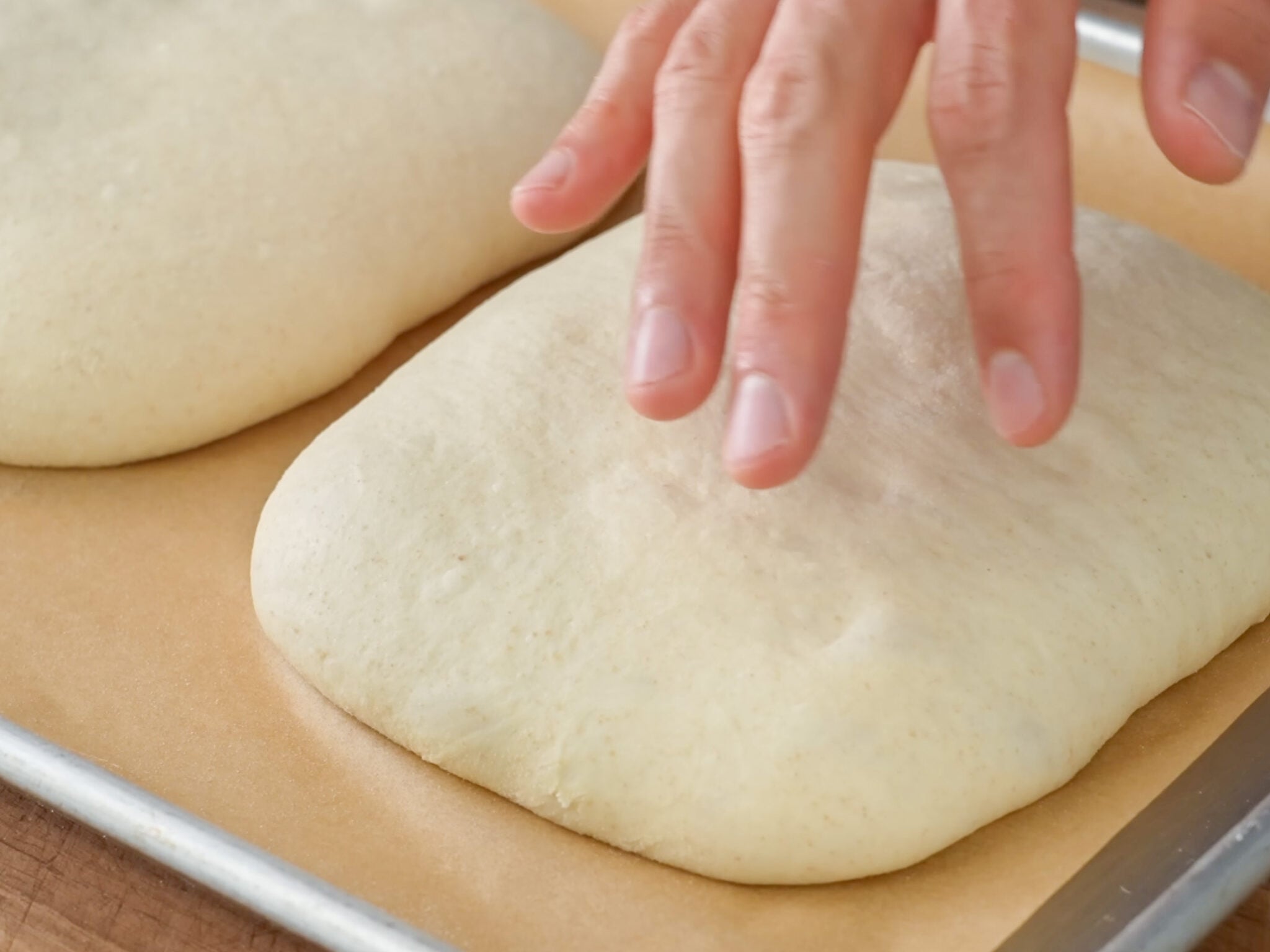 hand poking proofed bread dough