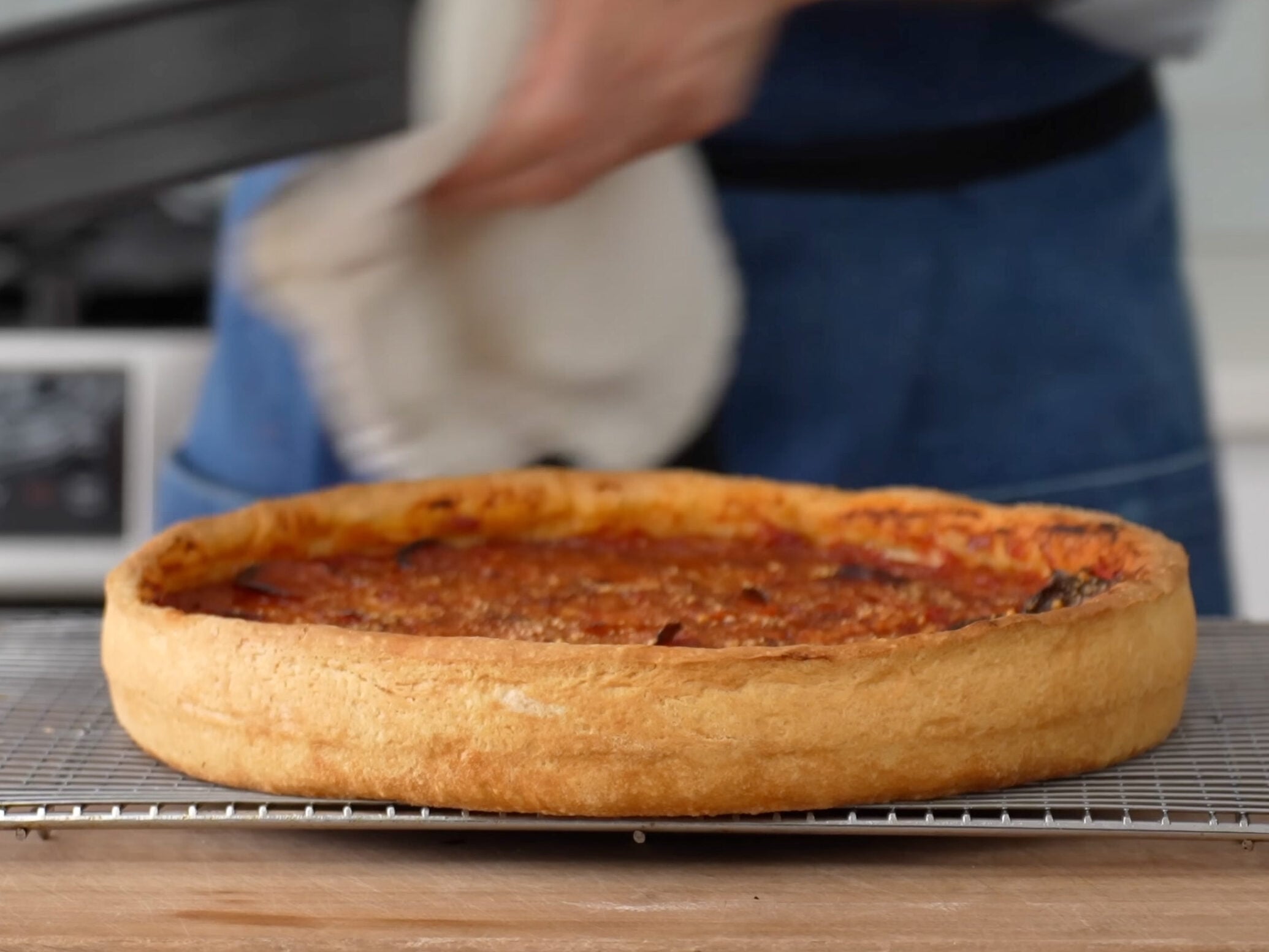 ban standing behind deep dish pizza