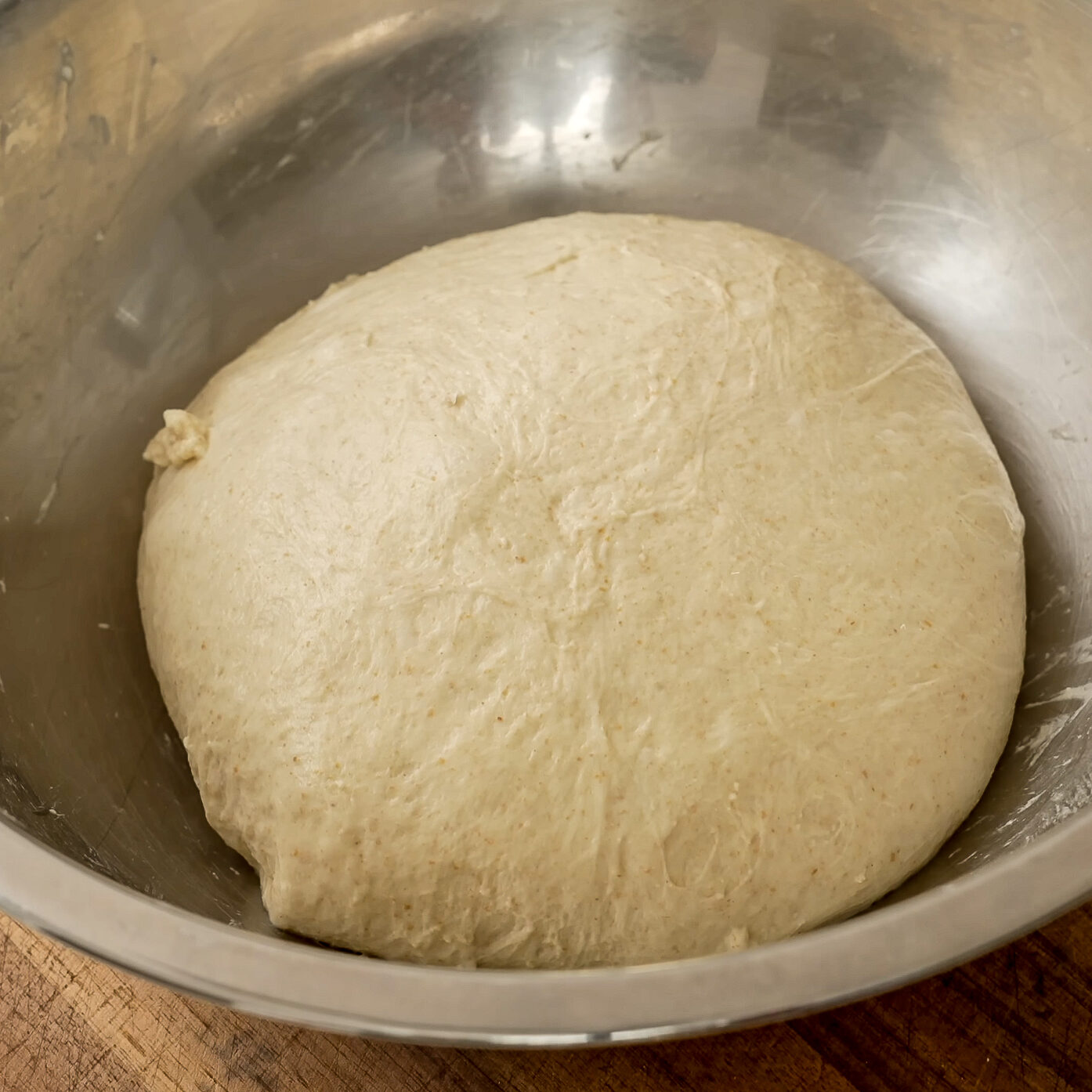 rounded ball of dough in metal bowl