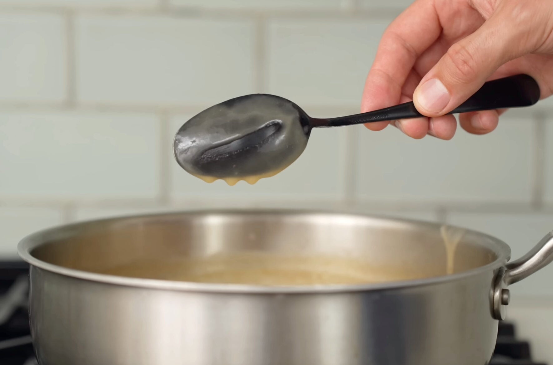 using black spoon to check gravy consistency