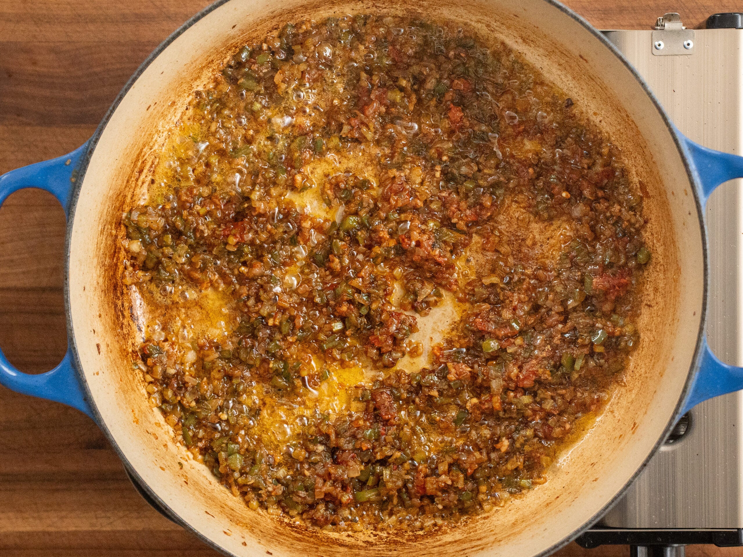 cooked diced veggies and bacon in blue dutch oven