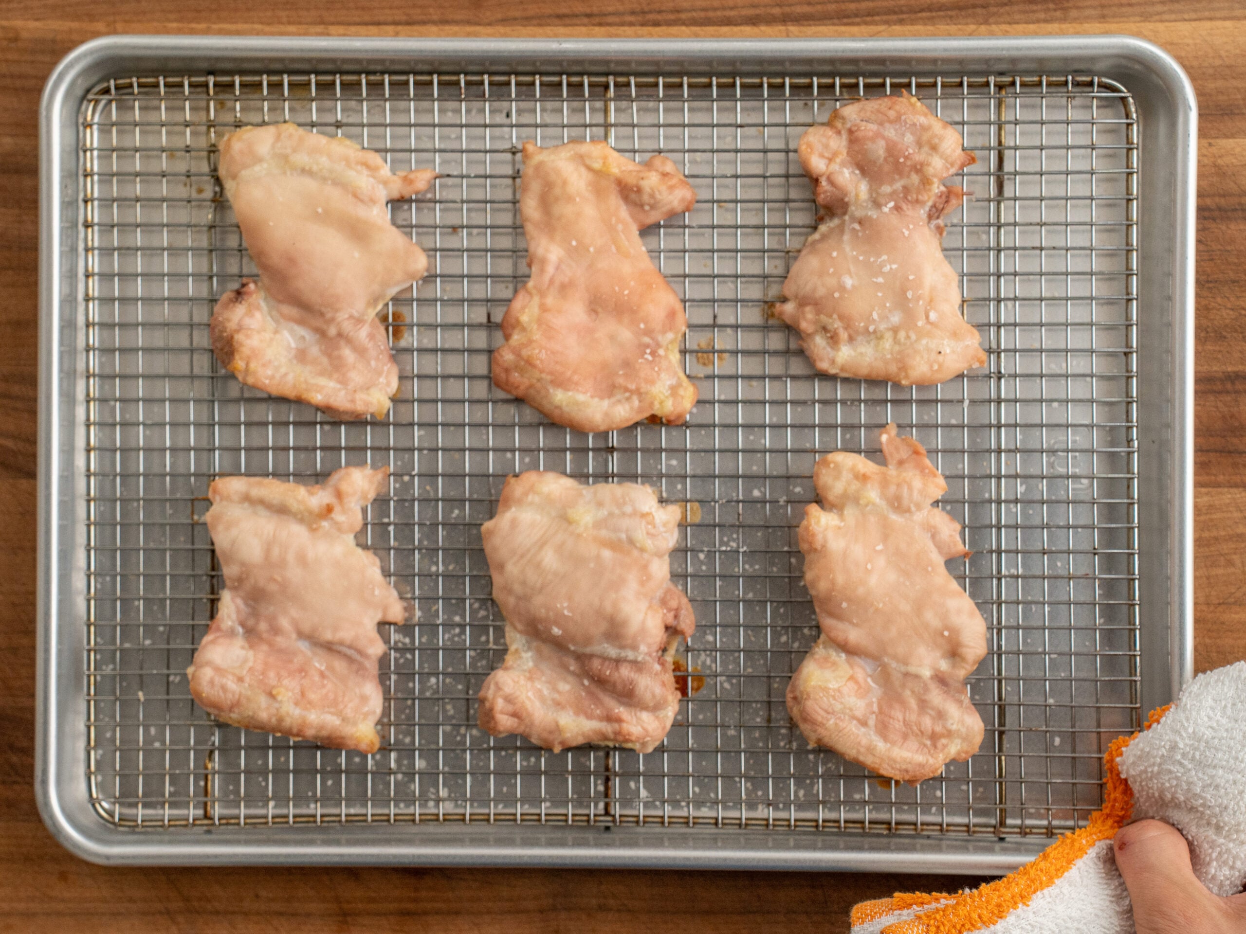 6 cooked chicken thighs on a wire rack