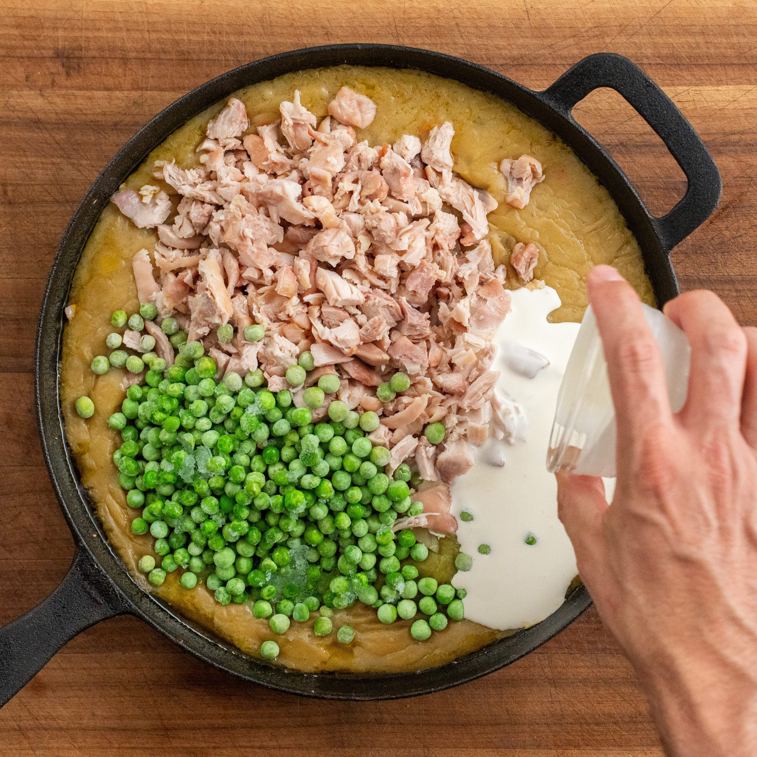 adding cream into chicken pot pie filling