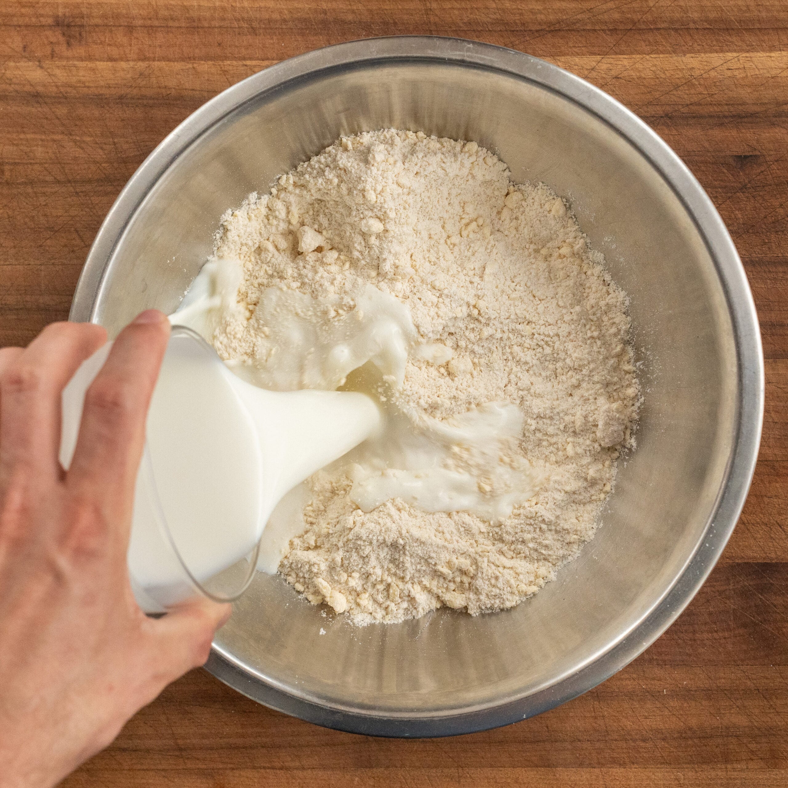 pouring buttermilk into biscuit dry ingredients