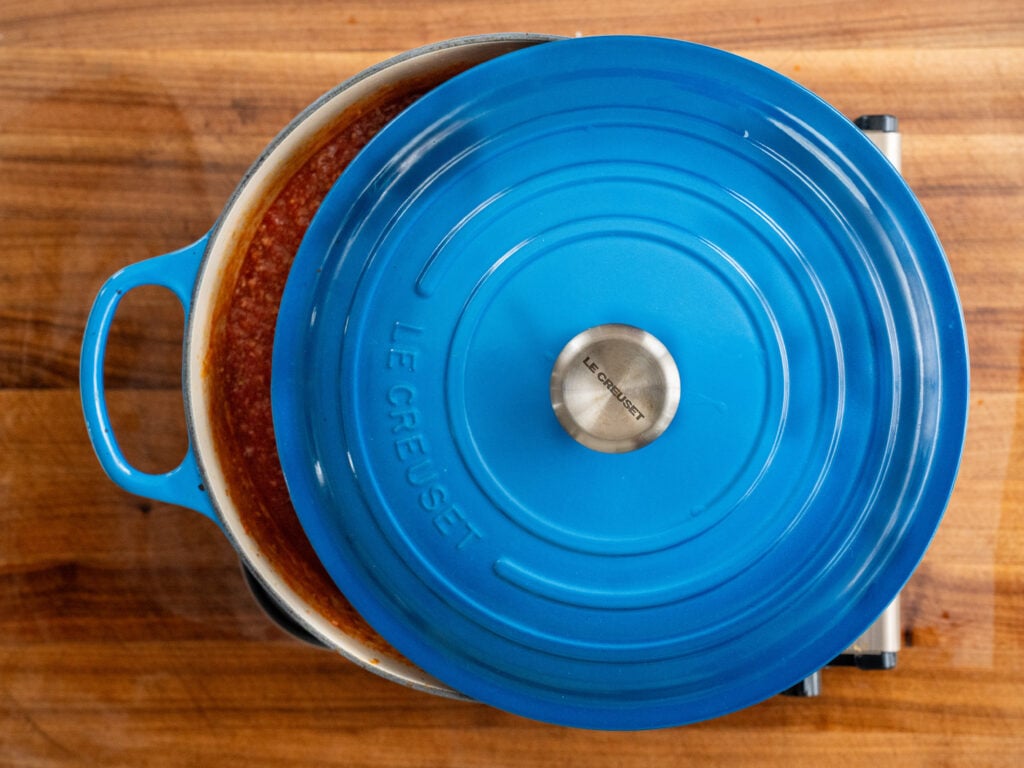 overhead shot of blue dutch oven with lid partially ajar